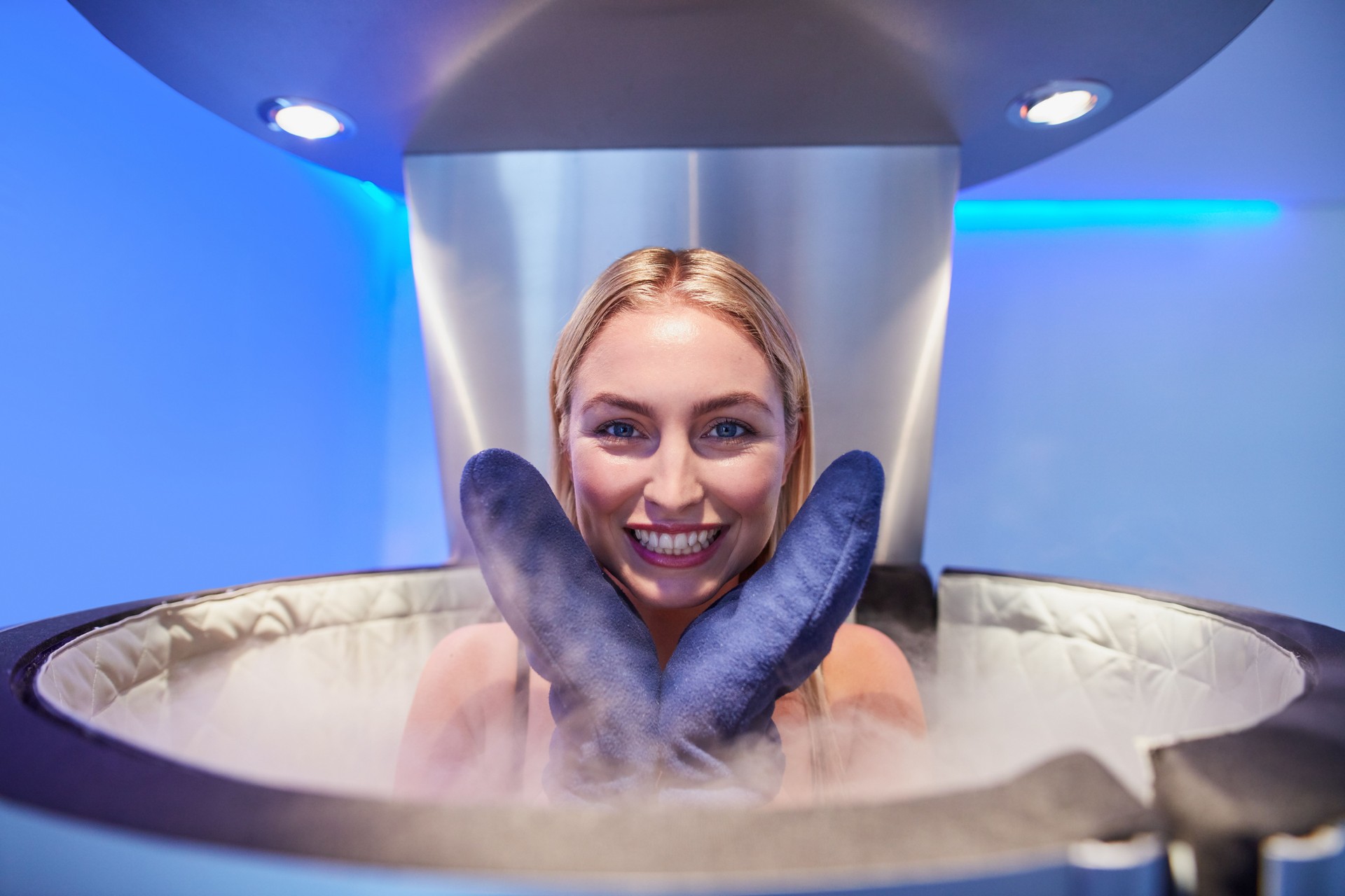 Cute young woman in cryosauna booth